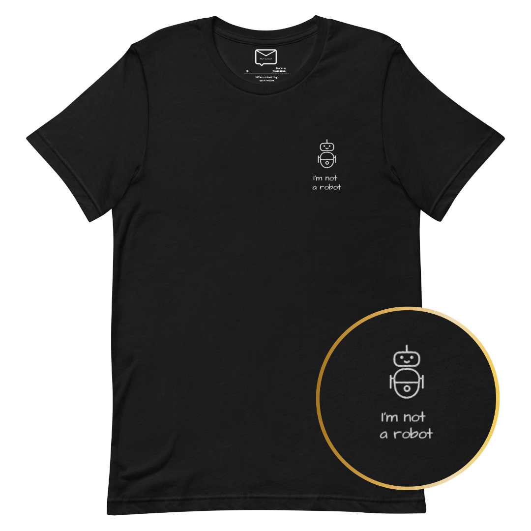 Front view of a black short-sleeved t-shirt featuring a small, line-art style illustration of a robot and the phrase "I'm not a robot" in a simple white font beneath it, located on the left side of the chest.
