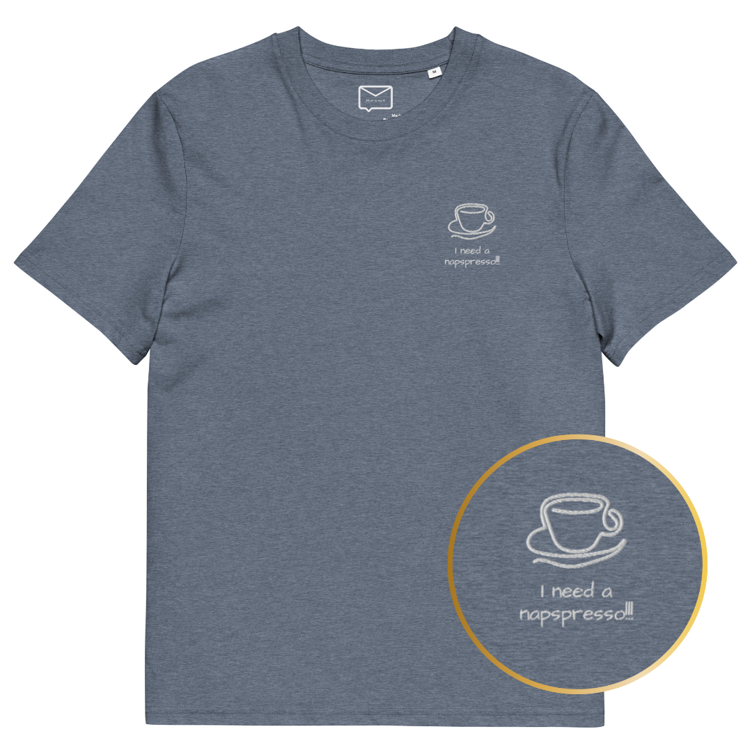 Front view of a greyish blue short-sleeved t-shirt featuring a small, line-art style illustration of a coffee cup on a saucer, with the humorous phrase "I need a napspresso!!" in a playful font beneath it, located on the left side of the chest