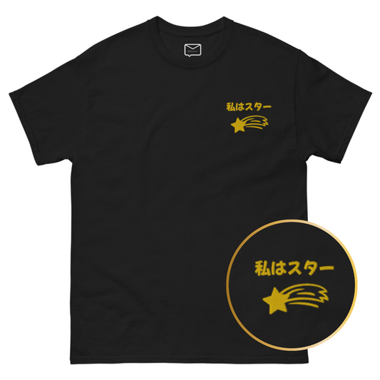 Front view of a black short-sleeved t-shirt featuring the Japanese phrase "Watashi wa Star" (translation: I am a star) in a stylized font, accompanied by a gold shooting star graphic beneath it, located on the left side of the chest.